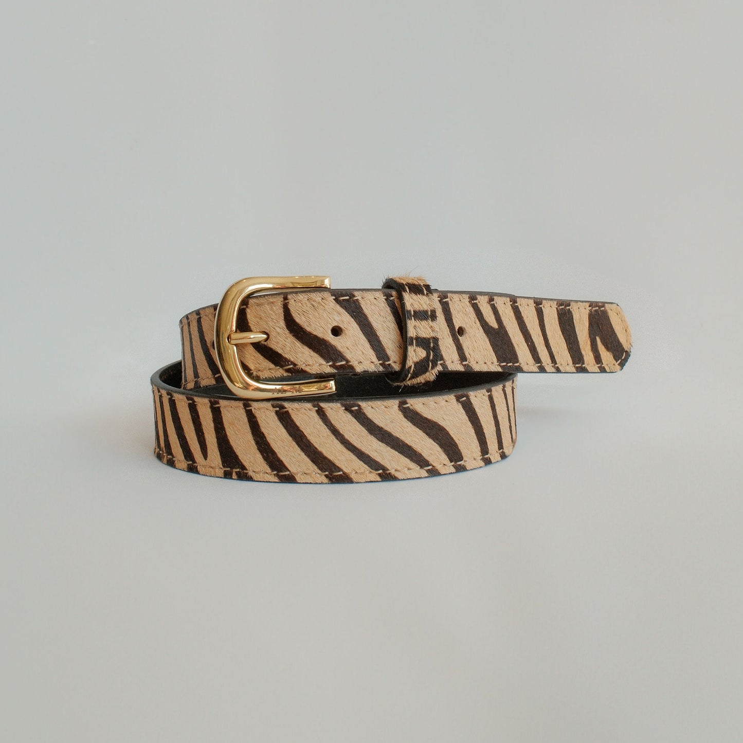 Zebra print belt on a light gray background